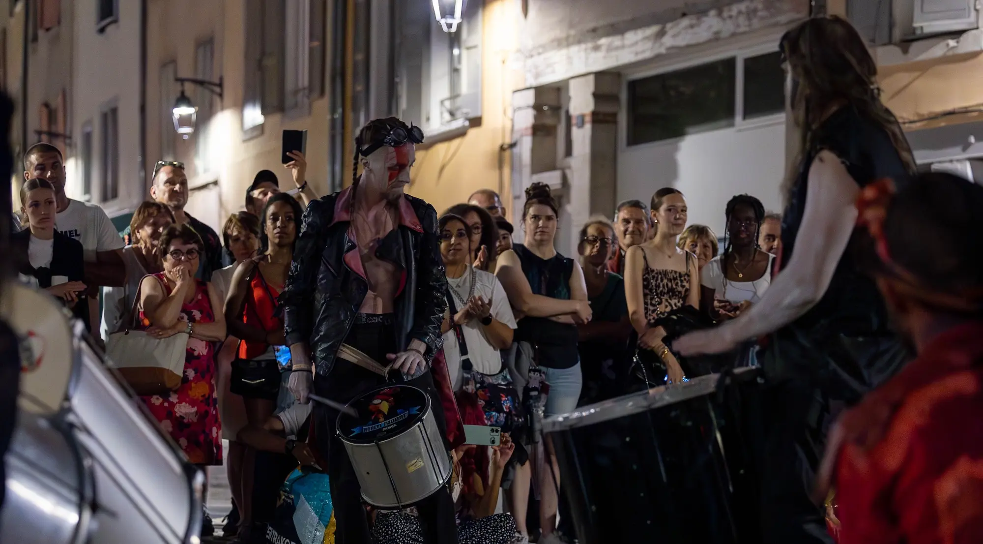 Performance nocturne de la batucada Arrête J’Adore au festival Interfolk, percussions brésiliennes et ambiance festive.