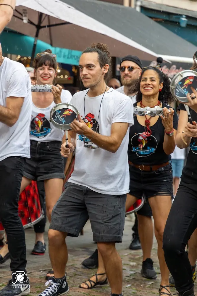 Défilé de la batucada Arrête J’Adore animant les rues de Lyon avec tambours, surdos et tamborims.