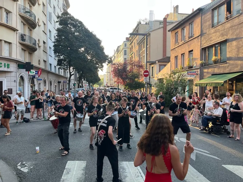 Groupe de batucada Arrête J’Adore en performance scénique lors d’un festival à Lyon.